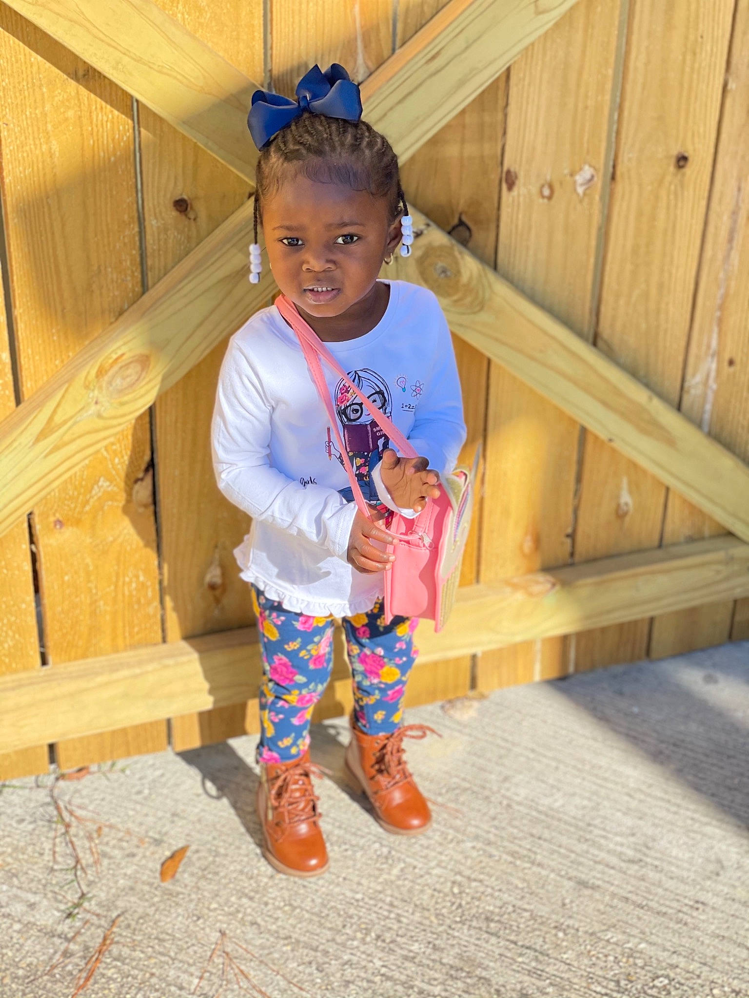 Liberty is registered to the contest to win money with this photo: baby_toddler_clothing, child, clothing, electric_blue, flooring, fun, grass, happy, hardwood, leisure, magenta, person, sleeve, standing, sunglasses, t_shirt, tints_and_shades, toddler, tree, wood