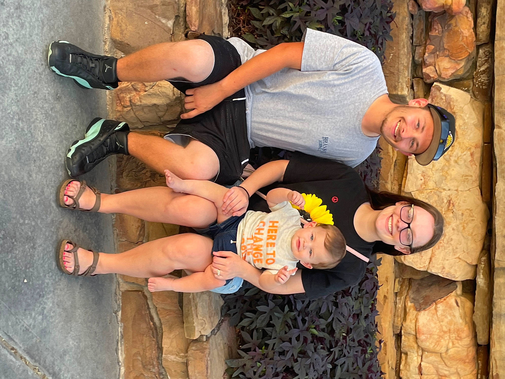 Ace is registered to the contest to win money with this photo: elbow, eyewear, fun, glasses, happy, hat, headwear, human_leg, interaction, joy, knee, leg, leisure, person, shorts, smile, sunglasses, thigh, tree, trunk