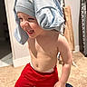 toddler, child, laughing, red_shorts, shirt_on_head, indoor, carpet, bare_chest, happy, playful, person, young_child, clothing, funny, smiling, home, cute, expression, casual, floor