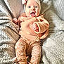 élyana a rejoint le concours — aidez-le/la à gagner de superbes lots ! baby, infant, smiling, headband, bow, cozy_clothing, blanket, soft_texture, patterned_pants, socks, happy, cute, child, portrait, indoor, laying_down, warm_colors, knitwear, expression, small_hands