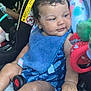 Harmoniee joined the competition — help win amazing prizes! baby, child, car_seat, blue_bib, blue_outfit, curly_hair, toy, car_interior, seat_belt, warning_label, infant, hand, leg, close_up, cute, child_seat, sitting, colorful, portrait, indoors