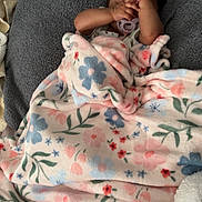 Harmoniee joined the competition — help win amazing prizes! baby, blanket, child, comfort, cozy, cushion, cute, fabric, face, floral_pattern, hand, indoor, infant, pacifier, person, relaxing, resting, sleeping, soft_texture, wrapped