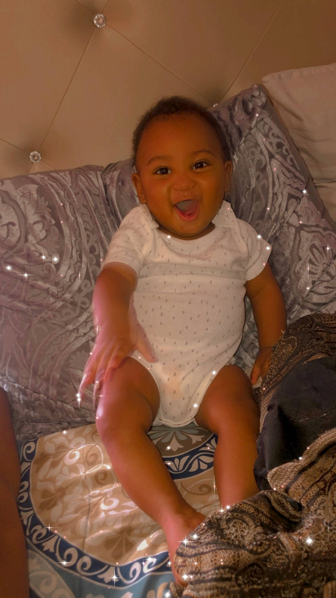 Emeries is registered to the contest to win money with this photo: baby, baby_toddler_clothing, cheek, comfort, dress, embellishment, eye, face, fun, hair, head, human_leg, iris, lap, leg, person, skin, sleeve, smile, thigh