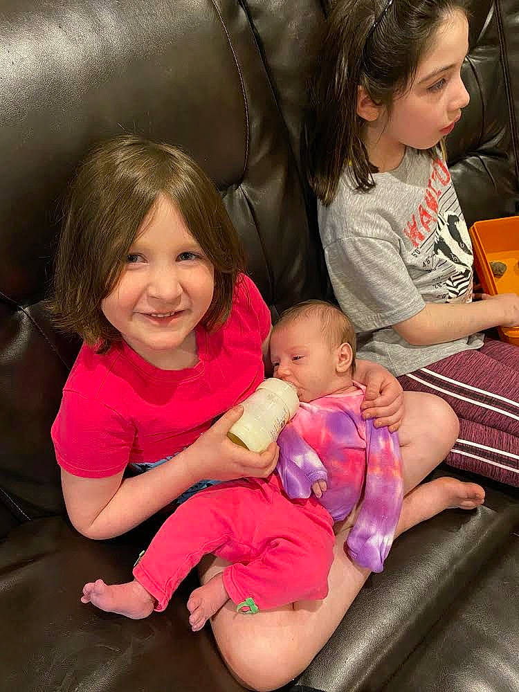 Bailee is registered to the contest to win money with this photo: cheek, comfort, face, facial_expression, finger, hairstyle, head, interaction, iris, joy, lap, leg, mouth, organ, person, pink, sharing, skin, smile, thigh