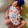 baby, sleeping, infant, blue_bow, star_pattern, onesie, blanket, soft_texture, cute, peaceful, newborn, child, legs, hands, face, headwear, relaxing, indoors, portrait, skin