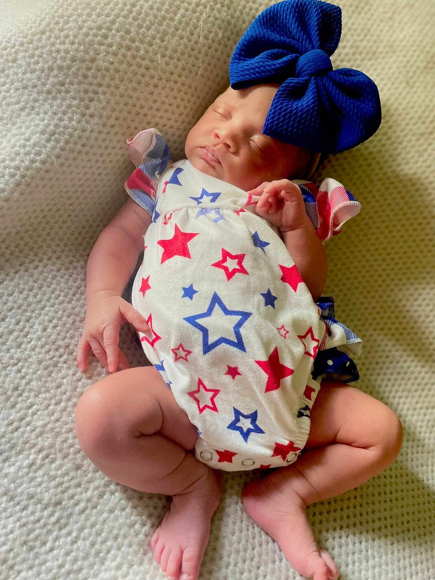 Khalynne joined the competition — help win amazing prizes! baby, sleeping, infant, blue_bow, star_pattern, onesie, blanket, soft_texture, cute, peaceful, newborn, child, legs, hands, face, headwear, relaxing, indoors, portrait, skin