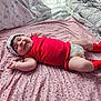 Nefertari is registered to the contest to win money with this photo: baby, infant, smiling, bed, blanket, pink, socks, diaper, hat, pillow, bedding, room, cozy, lying_down, newborn, chubby_legs, red_clothing, floral_pattern, sleep, cute