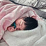 baby, infant, newborn, sleeping, pacifier, pink_blanket, white_blanket, bed, bedding, pillow, cozy, black_hair, hand, closed_eyes, peaceful, soft_texture, blanket_fold, indoors, portrait, resting
