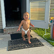 Carter joined the competition — help win amazing prizes! toddler, child, diaper, smile, outdoor, door, doormat, sunlight, grass, concrete, necklace, house, brick, shadow, foot, hand, toy, window_blind, happy, person
