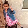 child, girl, peace_sign, denim_jacket, pink_dress, hearts, welcome_mat, door, window, concrete_floor, black_boots, outdoor, posing, smiling, young, casual_clothing, playful, wall, youth, happy