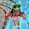 child, swimming_pool, water, goggles, floatie, thumbs_up, unicorn, pink, blue, happy, summer, fun, swimming, water_reflection, person, outdoor, playful, kid, safety, smile