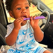 Na Cario joined the competition — help win amazing prizes! toddler, child, car, car_seat, nike, clothing, blue, white, sitting, curious, holding, object, shorts, tshirt, indoors, window, daylight, hair, person, footwear