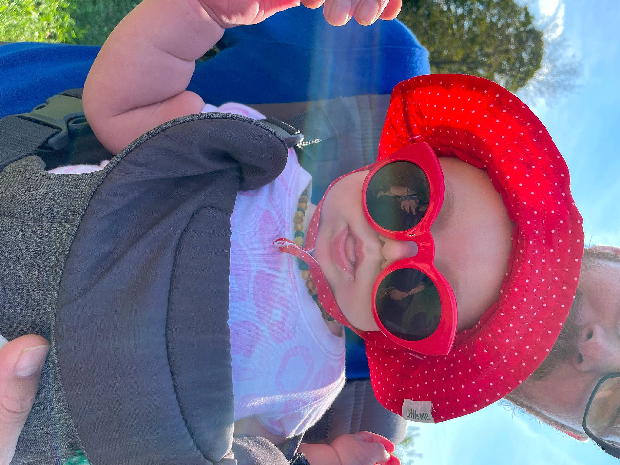 Melody is registered to the contest to win money with this photo: event, eyewear, gesture, glasses, goggles, happy, hat, headgear, leisure, mouth, person, personal_protective_equipment, petal, pink, recreation, summer, sun_hat, sunglasses, toddler, tree