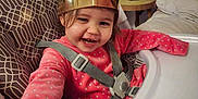 Kaëly a rejoint le concours — aidez-le/la à gagner de superbes lots ! toddler, child, high_chair, crown, smiling, happy, pink_clothing, straps, indoor, lamp, table, furniture, home, cute, person, baby, seat, reaching, cozy, portrait