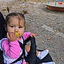 toddler, child, stroller, snack, pigtails, pink_clothing, outdoor, playground, fence, autumn_leaves, curious, socks, shoes, seatbelt, person, young_child, daylight, park, grip, baby