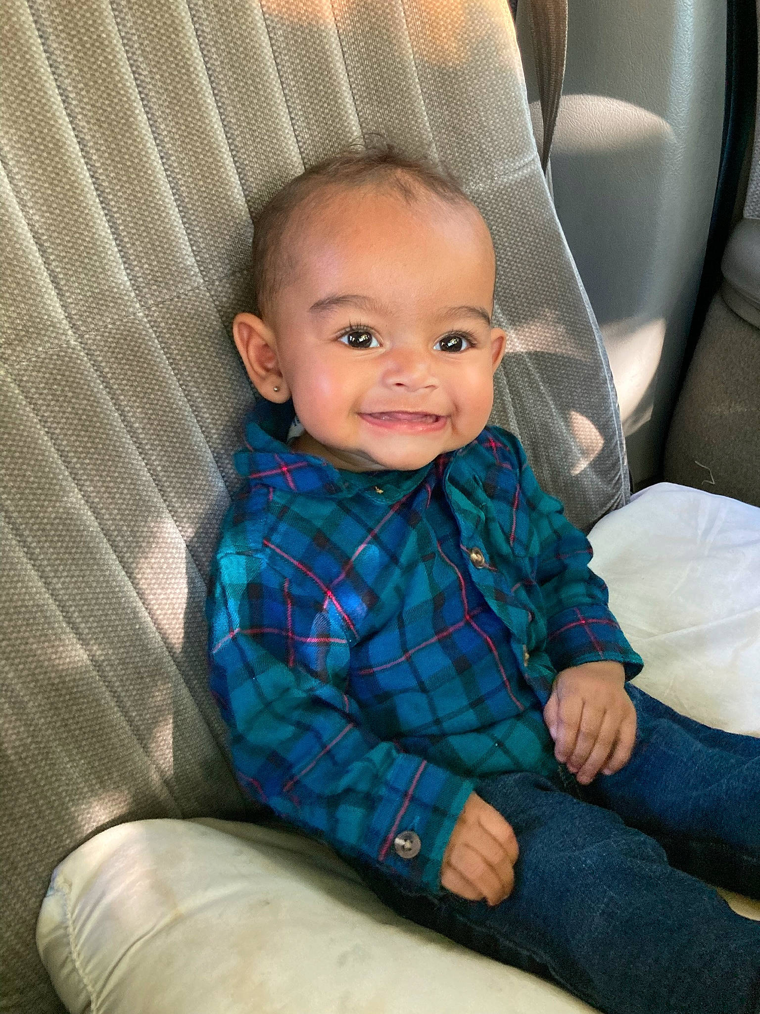 Enchanted is registered to the contest to win money with this photo: baby, baby_toddler_clothing, car_seat, cheek, child, comfort, couch, electric_blue, eye, grey, hairstyle, head, iris, joy, pattern, person, sitting, sleeve, smile, textile