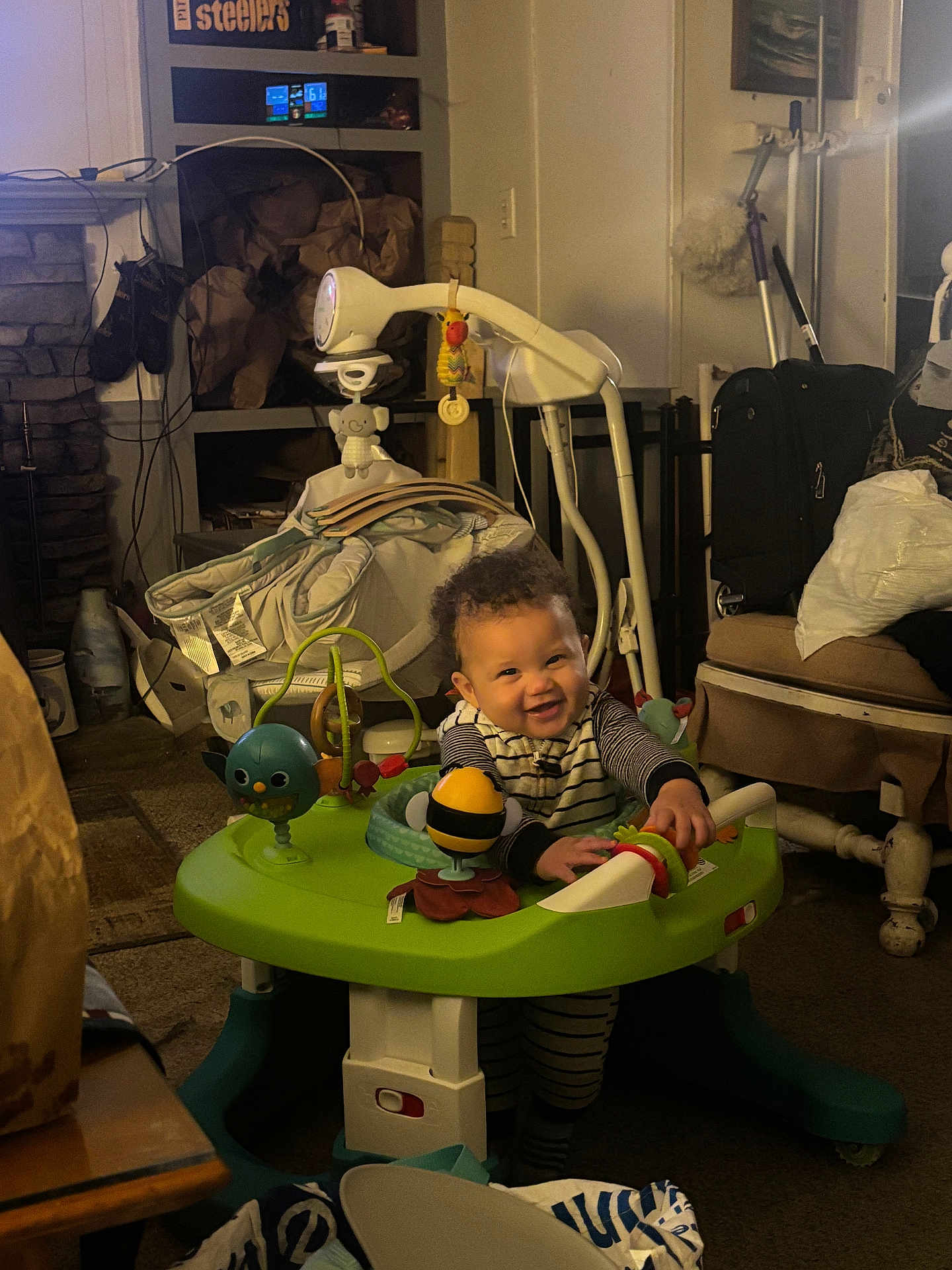 Ke-Shawn joined the competition — help win amazing prizes! activity_center, baby, bag, carpet, child, cozy, curly_hair, furniture, household_items, indoor, lamp, living_room, person, playtime, shelf, smile, striped_clothing, suitcase, toy, warm_lighting