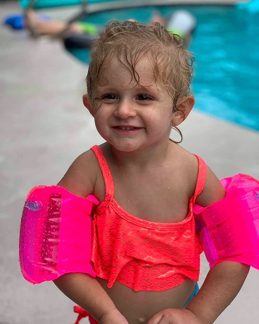 Mariella is registered to the contest to win money with this photo: arm, child, child_model, fun, happy, joy, leisure, lifejacket, neck, person, personal_protective_equipment, pink, play, shoulder, smile, summer, toddler, vacation, water