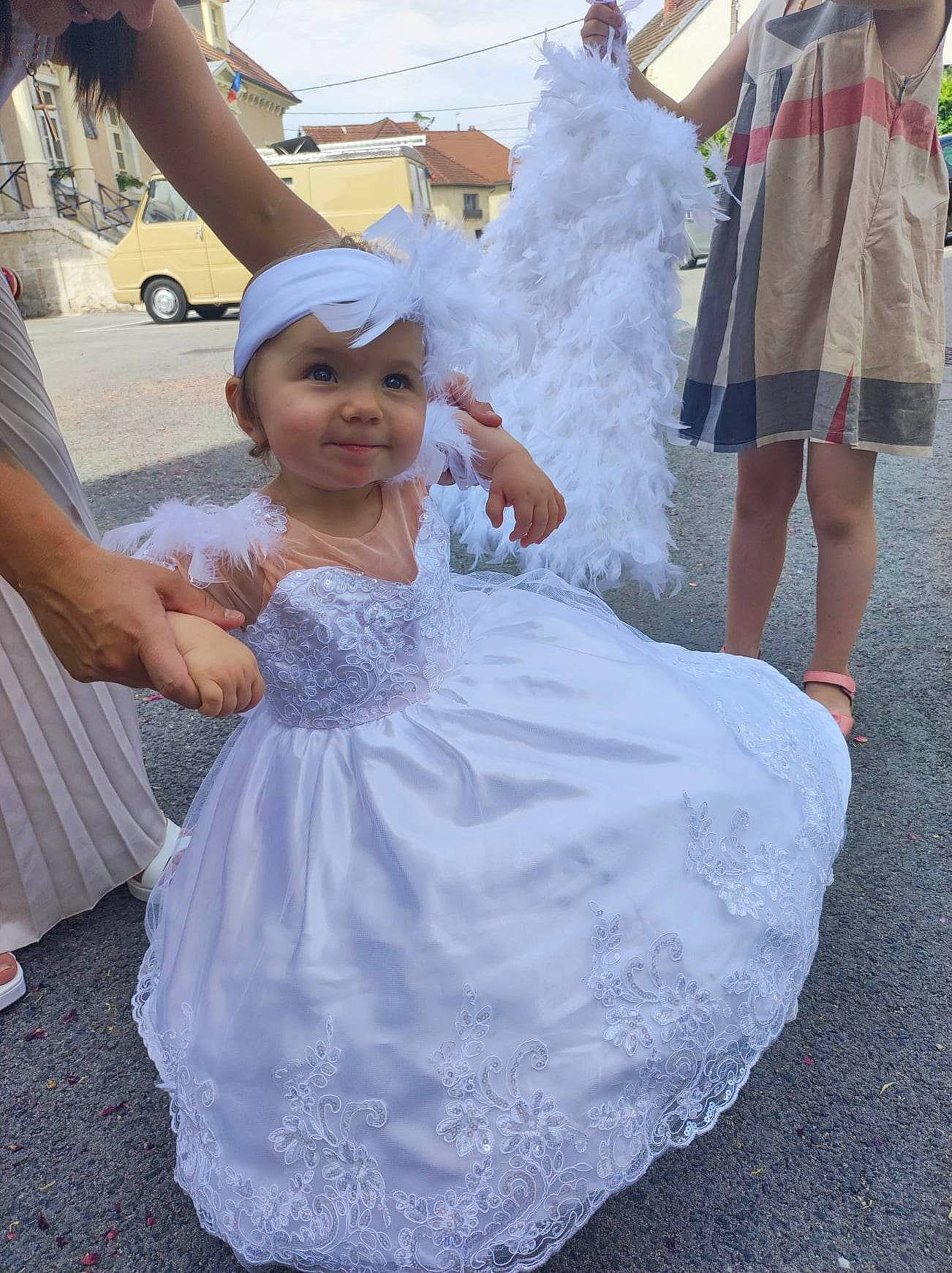 Shana a rejoint le concours — aidez-le/la à gagner de superbes lots ! bridal_accessory, bridal_clothing, bridal_party_dress, child, costume, dress, event, fun, gesture, gown, hairstyle, happy, headpiece, headwear, person, pink, road, sandal, smile, toddler
