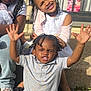 Noah is registered to the contest to win money with this photo: child, children, smiling, braids, beads, porch, steps, sunlight, happy, casual_clothing, jeans, sneakers, outdoor, family, playful, expression, sitting, friends, daylight, fun