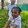 child, toddler, smiling, laughing, outdoor, grass, flowers, greenery, blurred_background, braided_hair, polo_shirt, bracelet, happy, two_children, nature, daylight, casual_clothing, portrait, playful, joy