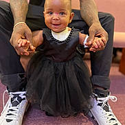 Love joined the competition — help win amazing prizes! baby, child, smiling, black_dress, pink_bow, tattooed_arms, white_sneakers, holding_hands, indoor, carpet, couch, person, cute, happy, portrait, support, fashion, footwear, seated_adult, closeup