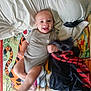baby, infant, smiling, blanket, cartoon, tiger, winnie_the_pooh, pillow, clothing, fabric, motion_blur, hand, foot, happy, child, lying_down, indoors, playful, cute, person