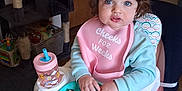Hayzleigh is registered to the contest to win money with this photo: child, toddler, highchair, bib, food, banana, divided_plate, sippy_cup, cup, snack, indoor, home, portrait, blue_eyes, short_hair, hair_clip, socks, chair, cat_tree, toy