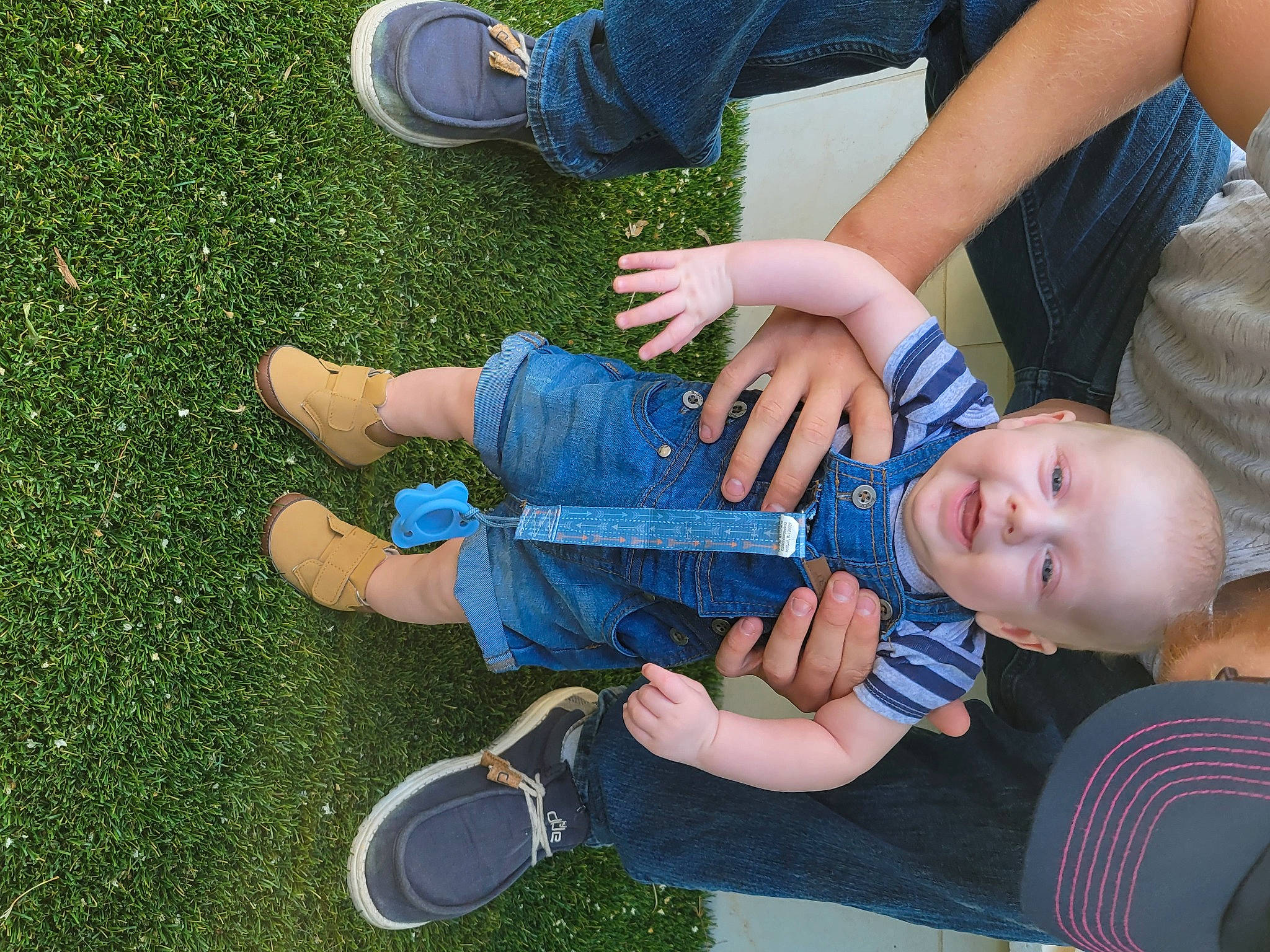 Atlas is registered to the contest to win money with this photo: baby, baby_toddler_clothing, blue, electric_blue, fun, gesture, grass, happy, leg, leisure, people_in_nature, person, plant, play, recreation, shoe, smile, sneakers, thumb, toddler