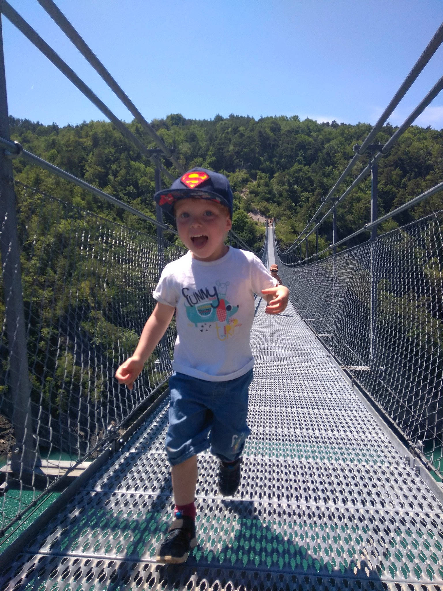 Matthias participe au concours pour gagner de l'argent avec cette photo : bridge, canopy_walkway, chain_link_fencing, child, headwear, leisure, nonbuilding_structure, person, rope, rope_bridge, suspension_bridge, vacation