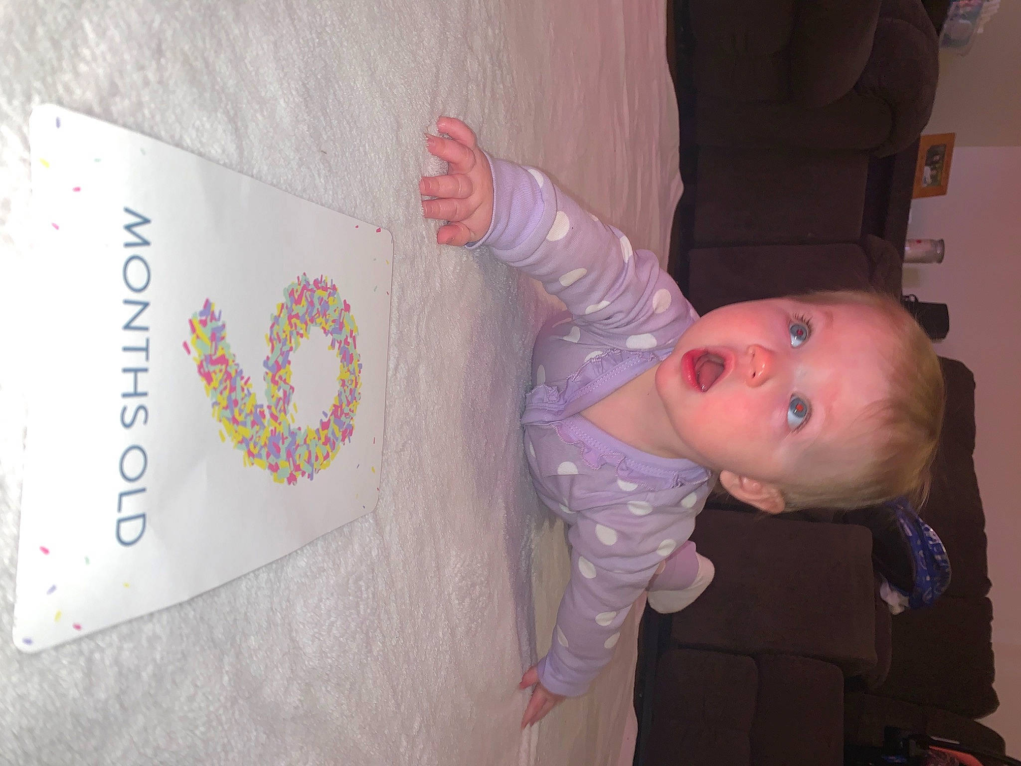 Skylar is registered to the contest to win money with this photo: baby, baby_products, baby_toddler_clothing, child, event, finger, font, fun, happy, person, pink, room, skin, sleeve, surprise, textile, thumb, toddler, visual_arts, wood