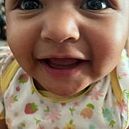 Melodee is registered to the contest to win money with this photo: baby, cheeks, child, close_up, clothing, cute, expression, eyes, face, floral_pattern, happy, indoors, infant, mouth, onesie, person, portrait, skin, smiling, young