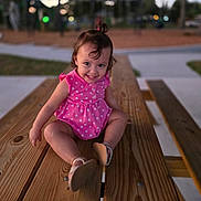Sophia joined the competition — help win amazing prizes! toddler, child, pink_dress, polka_dots, smile, sitting, wooden_table, outdoor, park, playground, evening, happy, cute, person, footwear, short_hair, nature, fun, young_child, casual