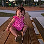toddler, child, pink_dress, polka_dots, smile, sitting, wooden_table, outdoor, park, playground, evening, happy, cute, person, footwear, short_hair, nature, fun, young_child, casual