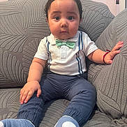 Josué joined the competition — help win amazing prizes! baby, child, infant, portrait, sitting, sofa, couch, bow_tie, shirt, trousers, socks, clothing, indoors, home, furniture, smiling, face, hair, bracelet, cushions