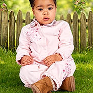 Gracie is registered to the contest to win money with this photo: toddler, child, grass, tree, flowers, pink_clothing, boots, outdoor, fence, nature, garden, portrait, sitting, cute, spring, greenery, young_child, daylight, person, innocence