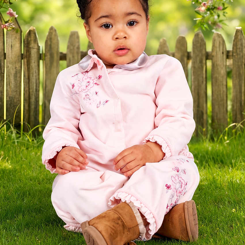 Gracie is registered to the contest to win money with this photo: toddler, child, grass, tree, flowers, pink_clothing, boots, outdoor, fence, nature, garden, portrait, sitting, cute, spring, greenery, young_child, daylight, person, innocence