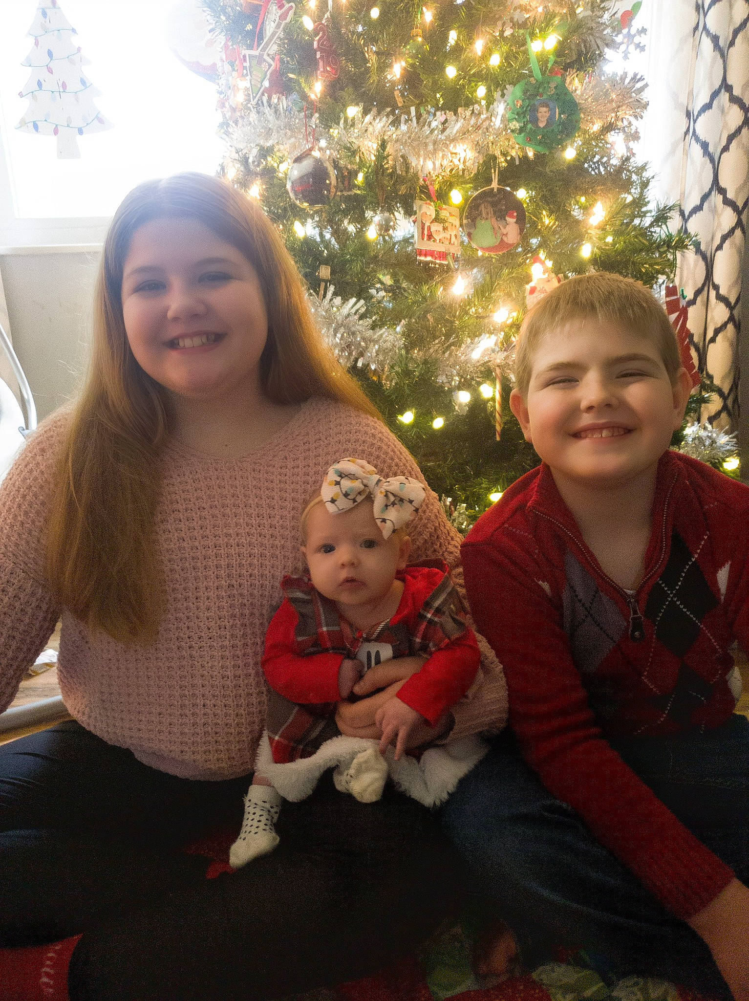 Rylie joined the competition — help win amazing prizes! arm, baby, christmas, christmas_decoration, christmas_ornament, christmas_tree, eye, facial_expression, fun, happy, head, holiday, iris, joy, lap, leaf, ornament, person, smile, standing