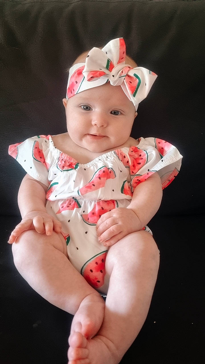 Vienna joined the competition — help win amazing prizes! baby, baby_products, baby_toddler_clothing, cap, carmine, dress, eye, fashion_accessory, finger, happy, headgear, headwear, human_body, human_leg, lip, pattern, person, pink, sleeve, smile
