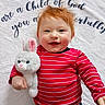 Jamesyn is registered to the contest to win money with this photo: baby, red_hair, striped_shirt, plush_toy, bunny, smiling, happy, child, blanket, text, indoor, cute, portrait, young_child, cuddly_toy, infant, lying_down, clothing, face, person
