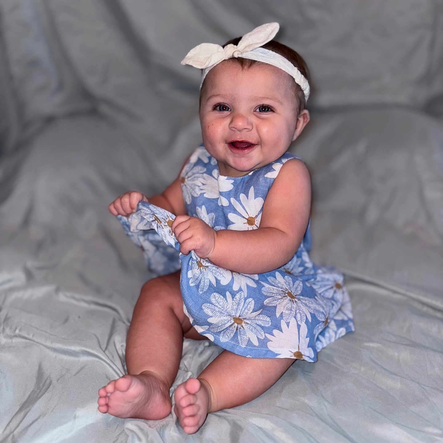 Dàvviana is registered to the contest to win money with this photo: baby, barefoot, blue_dress, child, cute, face, feet, floral_pattern, hands, happy, headband, indoors, infant, playful, portrait, sitting, skin, smiling, soft_fabric, young