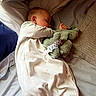 Echo is registered to the contest to win money with this photo: baby, sleeping, bed, blanket, stuffed_toy, pacifier_clip, pajamas, cozy, comfort, child, indoor, soft_toy, infant, rest, peaceful, cute, toddler, face, hand, head