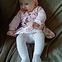 baby, child, smile, pink_headband, sweater, floral_skirt, tights, sitting, blanket, happy, cute, indoor, infant, headband, person, clothing, portrait, toddler, joyful, cozy