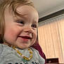 Maylynn is registered to the contest to win money with this photo: child, toddler, baby, smiling, close_up, indoors, necklace, shirt, curtains, window, furniture, hair, cheeks, eyes, teeth, happy, portrait, candid, living_room, person