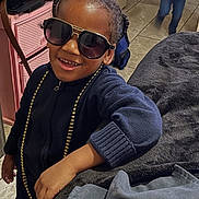 Jason joined the competition — help win amazing prizes! child, smiling, sunglasses, indoor, couch, gold_necklace, casual, happy, person, floor, tile, sweater, hair, hand, furniture, background, motion, kid, portrait, home