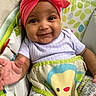 Romi joined the competition — help win amazing prizes! baby, smiling, headband, pink, infant, child, seated, colorful, patterned, clothing, hand, cute, indoors, portrait, happy, face, young, playful, fabric, comfort