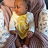 Romi joined the competition — help win amazing prizes! baby, infant, child, blanket, pink_socks, yellow_dress, white_cardigan, cushioned_seat, floral_pattern, smiling, portrait, indoors, cute, cozy, happy, sitting, soft_texture, warm, young_child, face