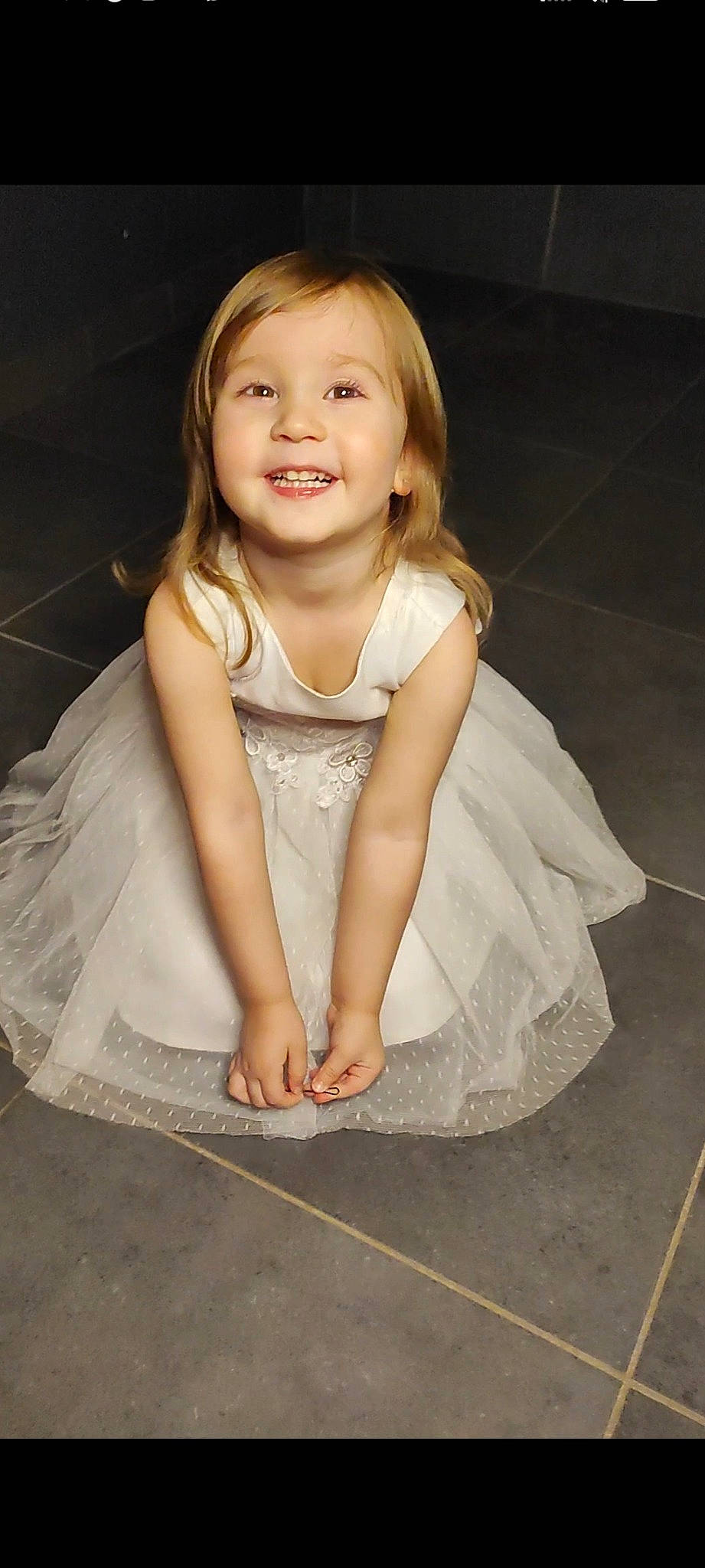 Talya participe au concours pour gagner de l'argent avec cette photo : baby, baby_toddler_clothing, bridal_accessory, child, dress, embellishment, eye, flash_photography, flooring, formal_wear, gesture, hair, happy, human_body, iris, joy, long_hair, person, shoulder, sleeve