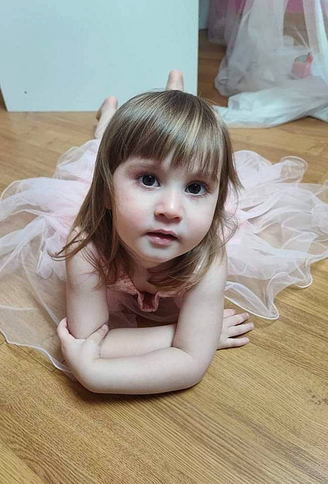 Talya a rejoint le concours — aidez-le/la à gagner de superbes lots ! bangs, blond, brown_hair, child, dress, eyelash, flash_photography, floor, flooring, happy, hardwood, human_body, human_leg, iris, leg, long_hair, person, skin, textile, toddler