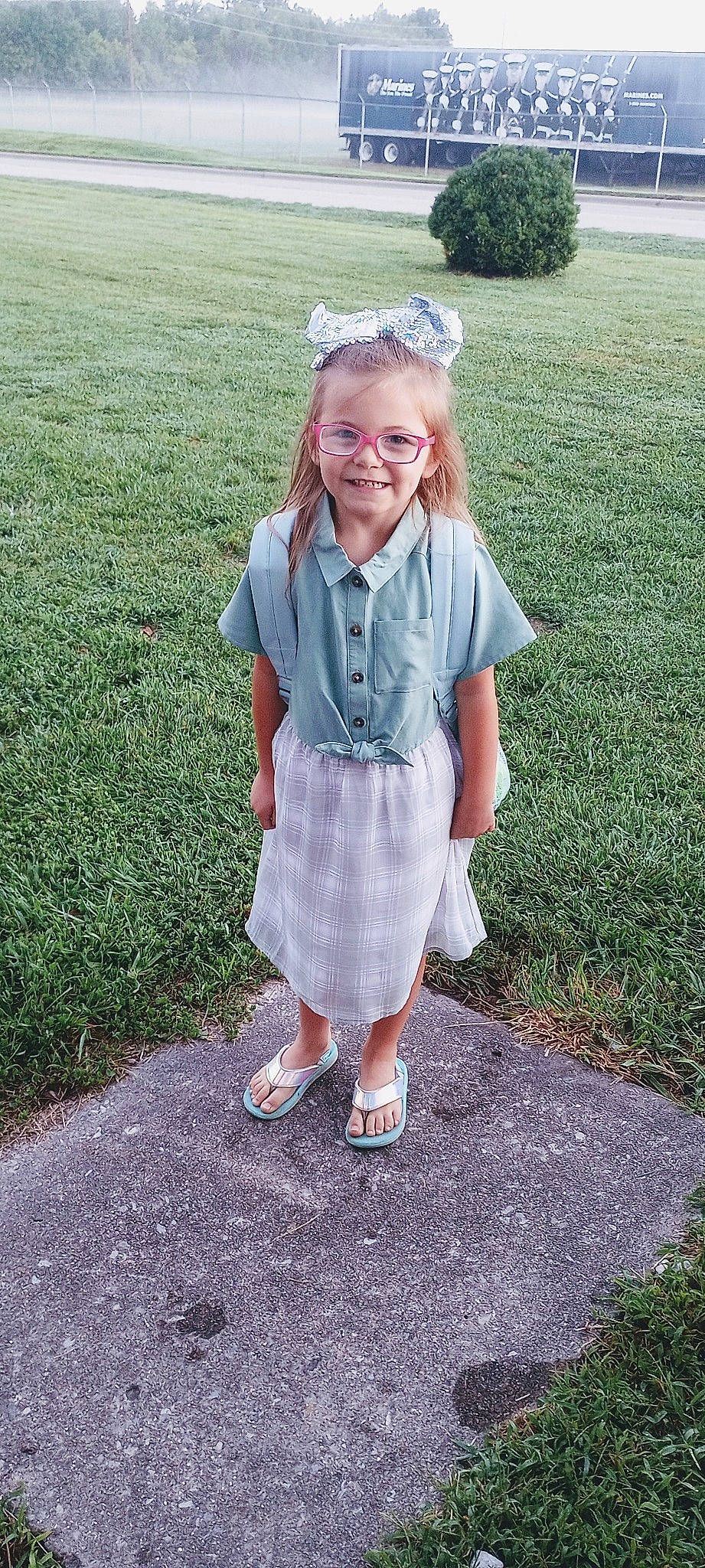 Lucy is registered to the contest to win money with this photo: baby_toddler_clothing, child, clothing, dress, face, fun, grass, hair, happy, head, joy, lawn, leg, pattern, people_in_nature, person, plant, sandal, sleeve, smile